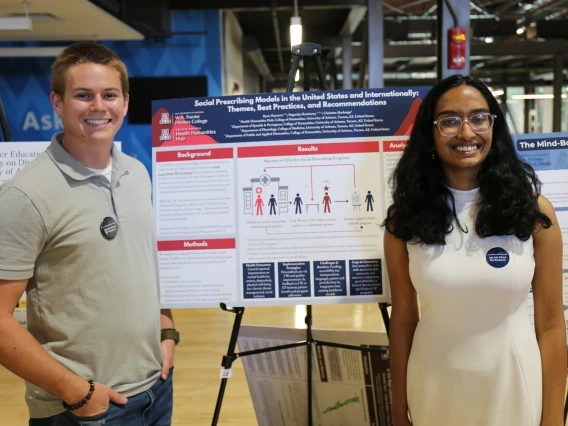 Students standing in front of a research poster.