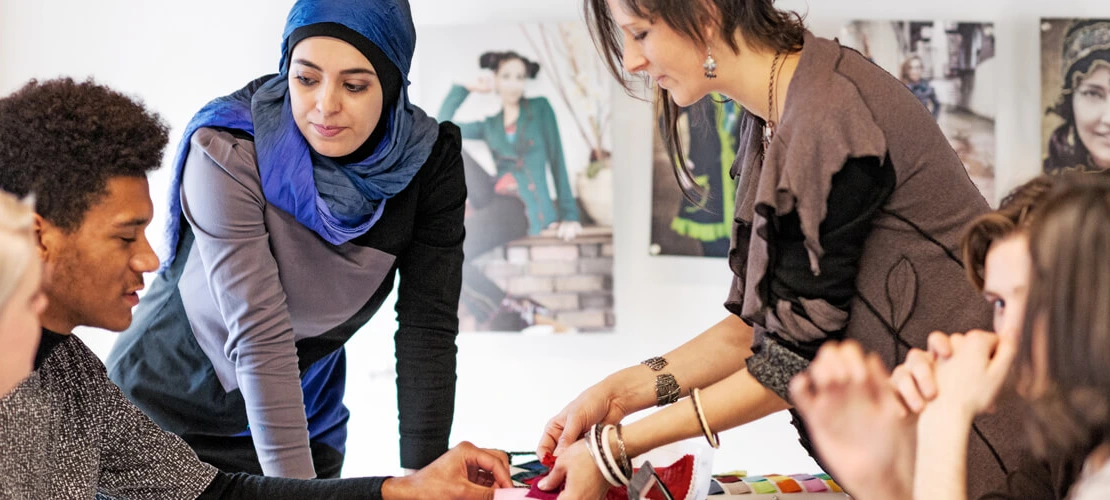 group of students discussing fabric swatches