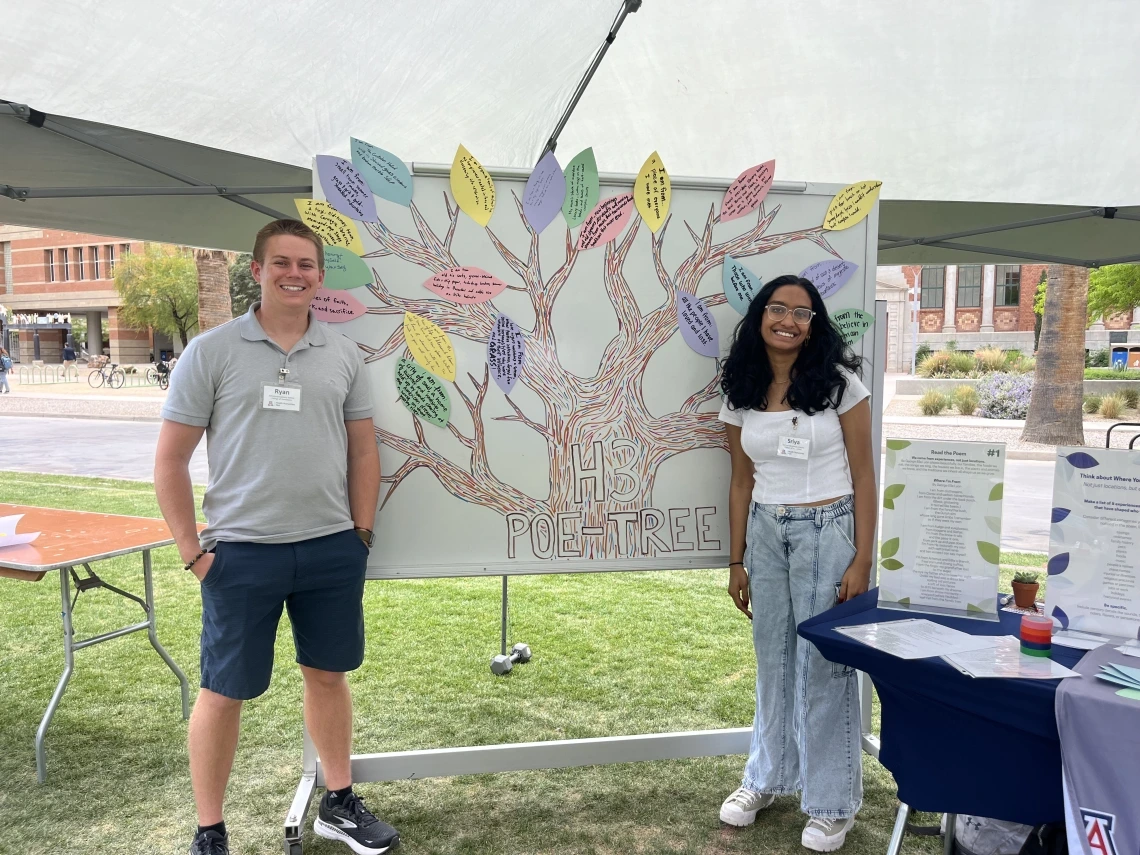 Students outdoors standing next to a poetry display.
